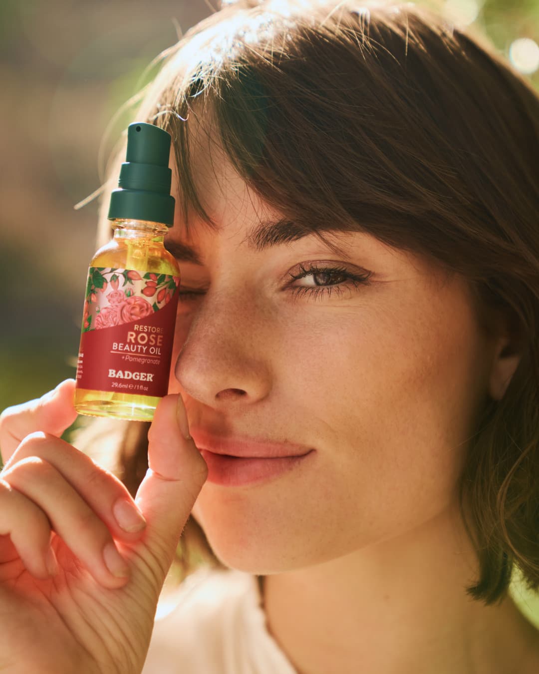 Woman holding Badger Rose Beauty Oil close-up — natural skincare product photography | Black Rabbit Creative